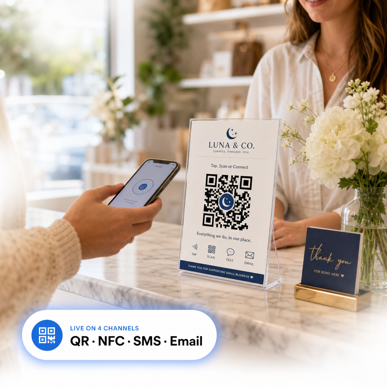 Branded QR/NFC tent card on a counter with a customer tapping their phone — badge reads 'Live on 4 channels: QR · NFC · SMS · Email'.
